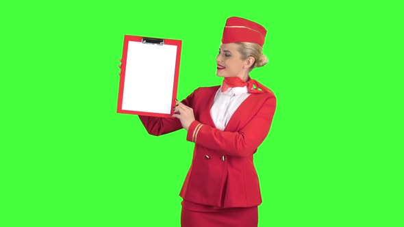 Stewardess Raises a Red Folder with a White Sheet of Paper. Green Screen