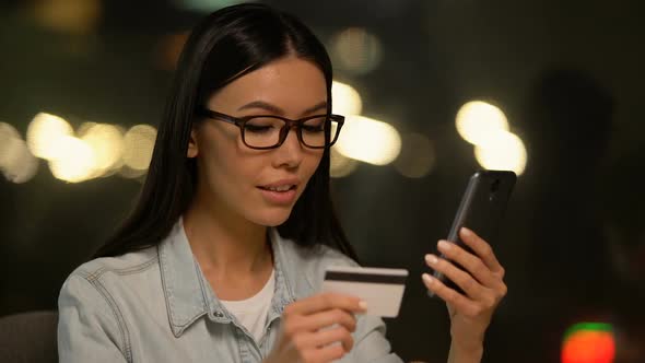 Asian Woman Paying Bills via Cell Phone Apps, Easy Online Shopping, Banking