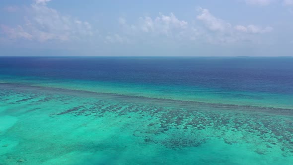 Beautiful fly over travel shot of a white paradise beach and blue water background in high resolutio