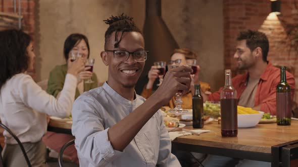 Portrait of Young African Man Dining with Friends