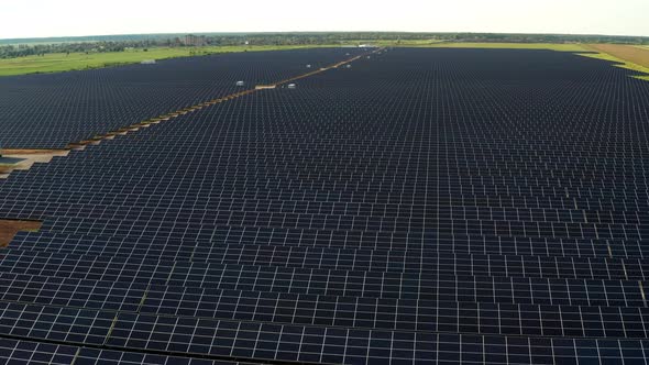 Top view of the power plant with solar panels. Beautiful green fields.