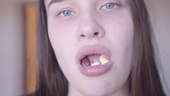 Bad Looking Woman Face Holding Many Pills in Her Mouth