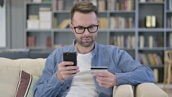 Portrait of Young Man Making Online Payment on Smartphone