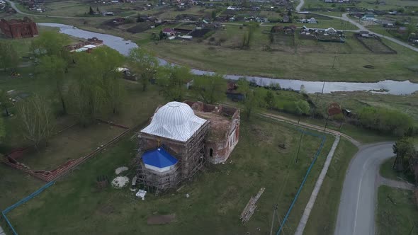 Aerial view of old village with church and old houses on the high bank of the river 07