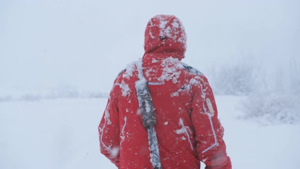 A Male Traveler Walks in a Heavy Snowfall Trying to Get Out