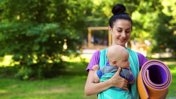 Fit Mom Carrying Baby in Sling To Yoga Class