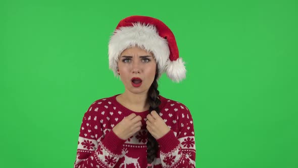 Portrait of Sweety Girl in Santa Claus Hat Is Talking About Something Then Making a Hush Gesture