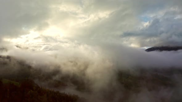 Flight Through Blue Sky with Clouds Over Mountain