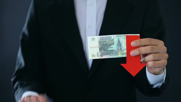 Businessman Holding Russian Ruble Banknotes Showing Thumbs Up and Down, Falling