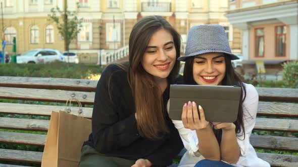 Female Friends Watch Something on the Tablet Outdoors