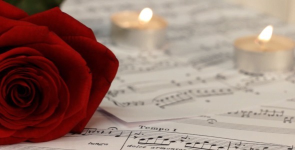 Red Rose and Candles on Sheet Music