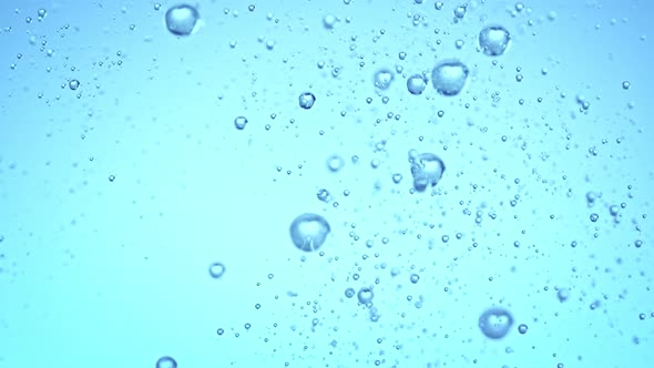 Super Slow Motion Shot of Rising Various Bubbles in Water on Light Blue Background at 1000 Fps