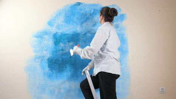 Professional Designer in Shirt Paints New Apartment Wall