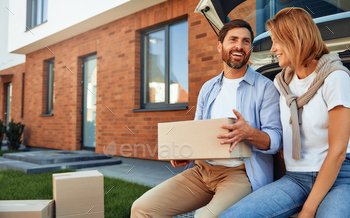 and unloading luggage in boxes to their new home. Renting and buying a home. Moving concept.