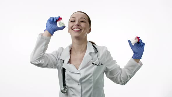 Funny Beautiful Smiling Doctor Dancing with Packs of Pills in Hands, Having Fun