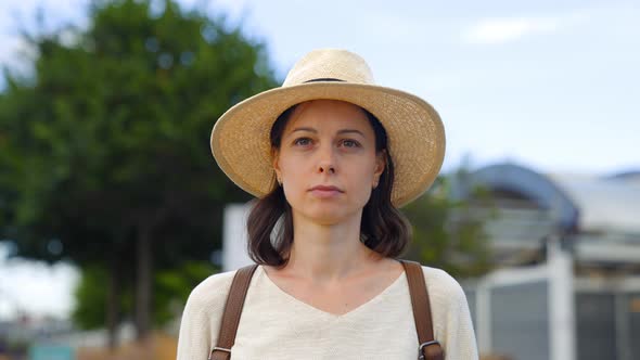 Young girl in a hat looking at the camera in the park