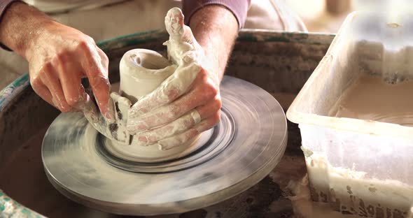 Mid section of potter making pot