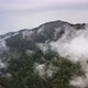 Flying over the mountains through the fog and clouds. - VideoHive Item for Sale