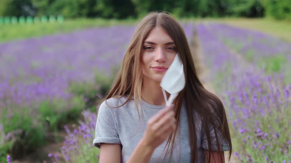 Woman Taking Off Face Mask Outdoors