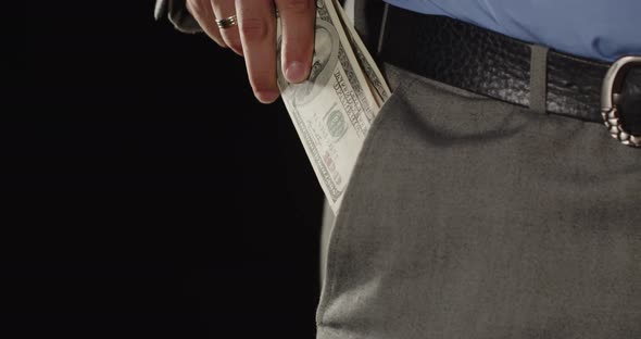 Male Hand Puts Dollar Bills In His Pocket