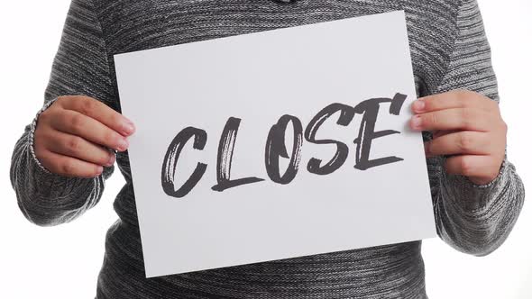 A person holding a sign with the message and the word "close"