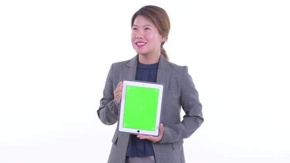 Happy Young Asian Businesswoman Thinking While Showing Digital Tablet