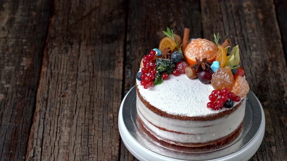 Festive New Years Cake Decorated with All Sorts of Fruits Spinning on a Rotating Stand