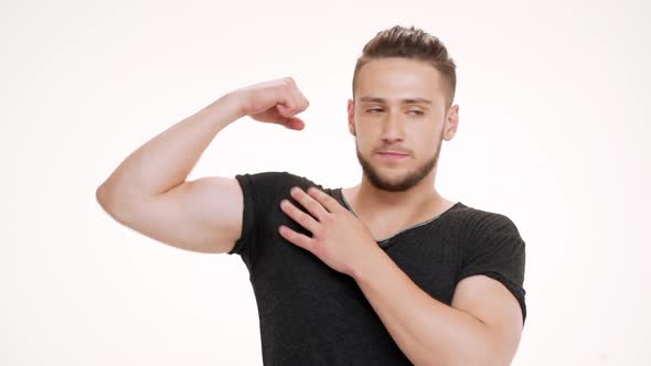 Portrait of Young Handsome Man Showing Muscles