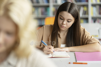 Pensive smart school girl taking notes, learning language in classroom. Back to school, education