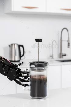 Real robot's hand and French press with black coffee. Concept of  robotic process automation