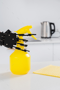 Real robot's hand with spray cleaner in white kitchen. Concept of  robotic process automation