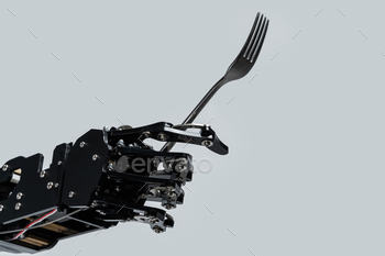 Real robot's hand with fork. Concept of AI development and robotic process automation
