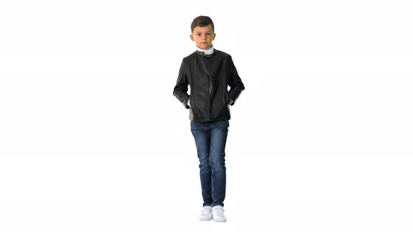 Young Boy in a Leather Jacket Walking with His Hands in His Pockets on White Background