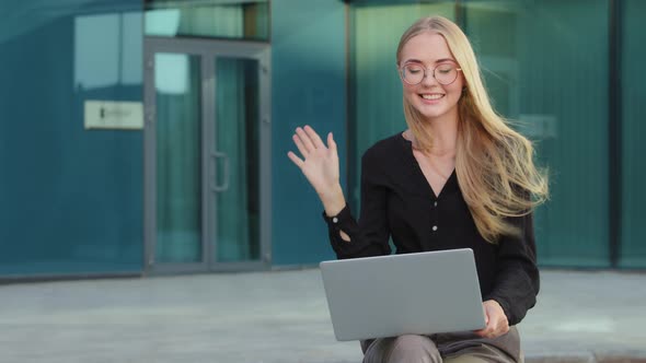 Euphoric Caucasian European Blonde Millennial Girl with Glasses Sitting Outdoors Using Laptop Got