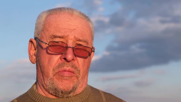 A sad, depressed old grandfather, a sad elderly man, talks about health problems