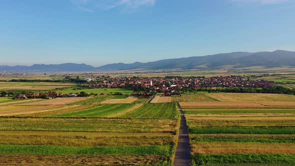 Flying towards Sancraieni, idyllic European village among farmland, Romania