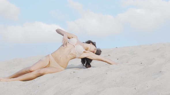 Gorgeous Woman in Beige Bikini Posing Sensually on Sand in the Desert