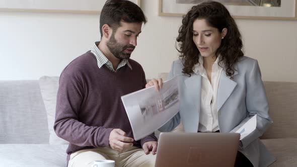 Front View of Two Architects Talking with Client Via Laptop