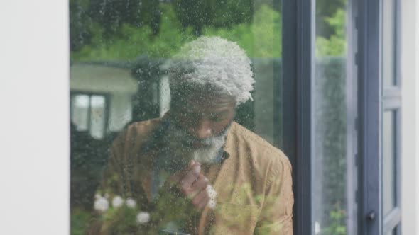 Video of sad african american senior man looking out the window