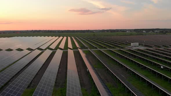 Aerial Drone View Into Large Solar Panels at a Solar Farm at Cloudy Summer Evening