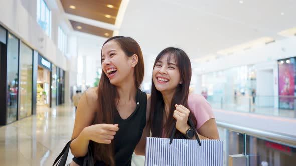 Asian young women friends shopping in department store mall during sale season at end of the year.