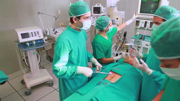 Surgeons operating a patient belly