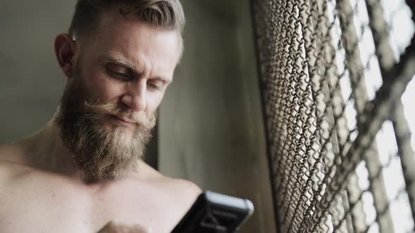 Man with Bandholz Beard Texting on Phone