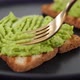 Hands with fork spreading mashed avocado on toasted bread - VideoHive Item for Sale