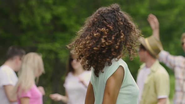 Young Pretty Woman With Curly Hair Dancing at Picnic With Friends, Summertime