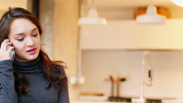 Woman talking on mobile phone in living room