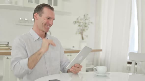 Middle Aged Man Doing Video Call on Tablet at Home