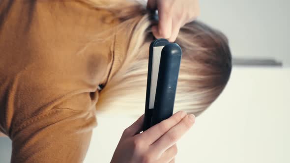 Vertical Video Woman Straightens Her Hair