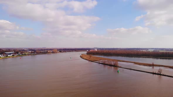 Aerial Flying Over Oude Maas In Barendrecht With Blue Sky And Clouds In View And Cargo Ship Approach