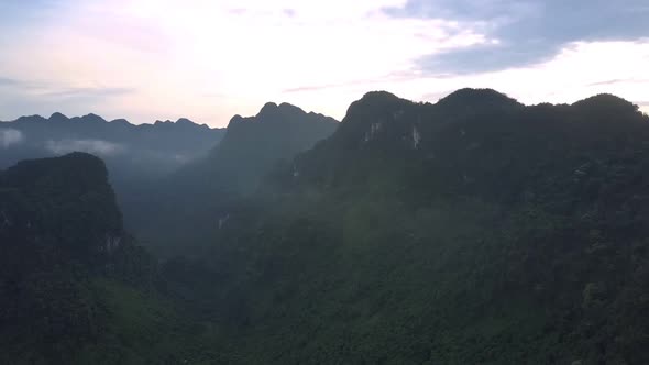 Mountain Peaks Among Fog and Hills Covered with Green Forest